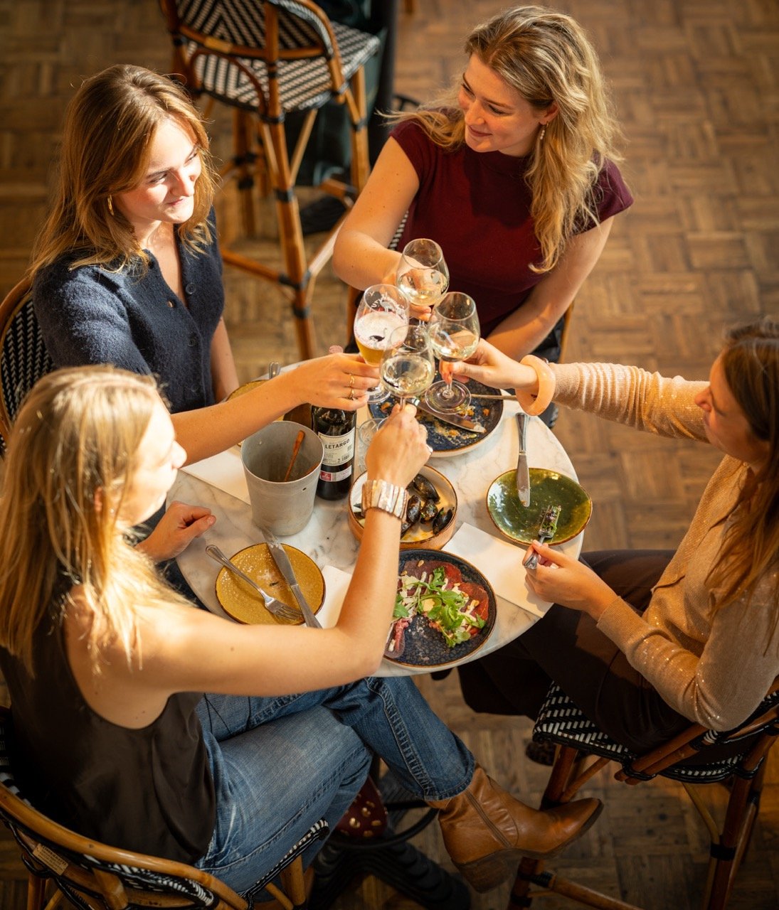 Shared dining gerechten en proosten aan tafel bij Lola's